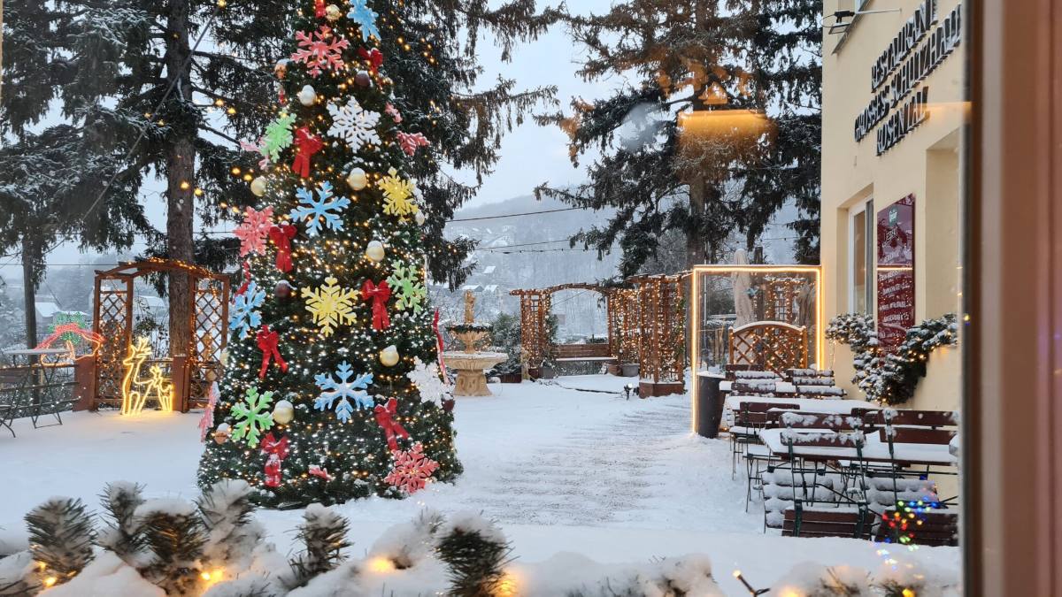 Geschmückter Christbaum im verschneiten Gastgarten